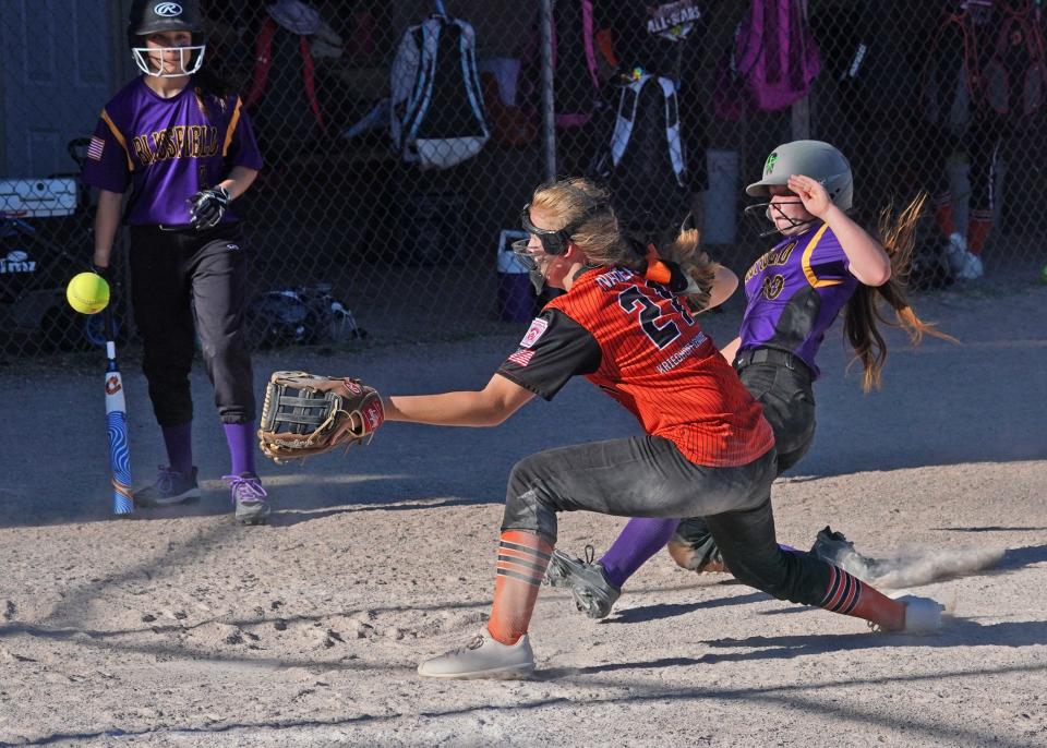 Blissfield's Adison Robinson slides home as Tecumseh's Lauren Nadeau fields the throw back to the plate during the Michigan Little League Softball District 16 10-11-12 Championship Thursday at Mitchell Park.