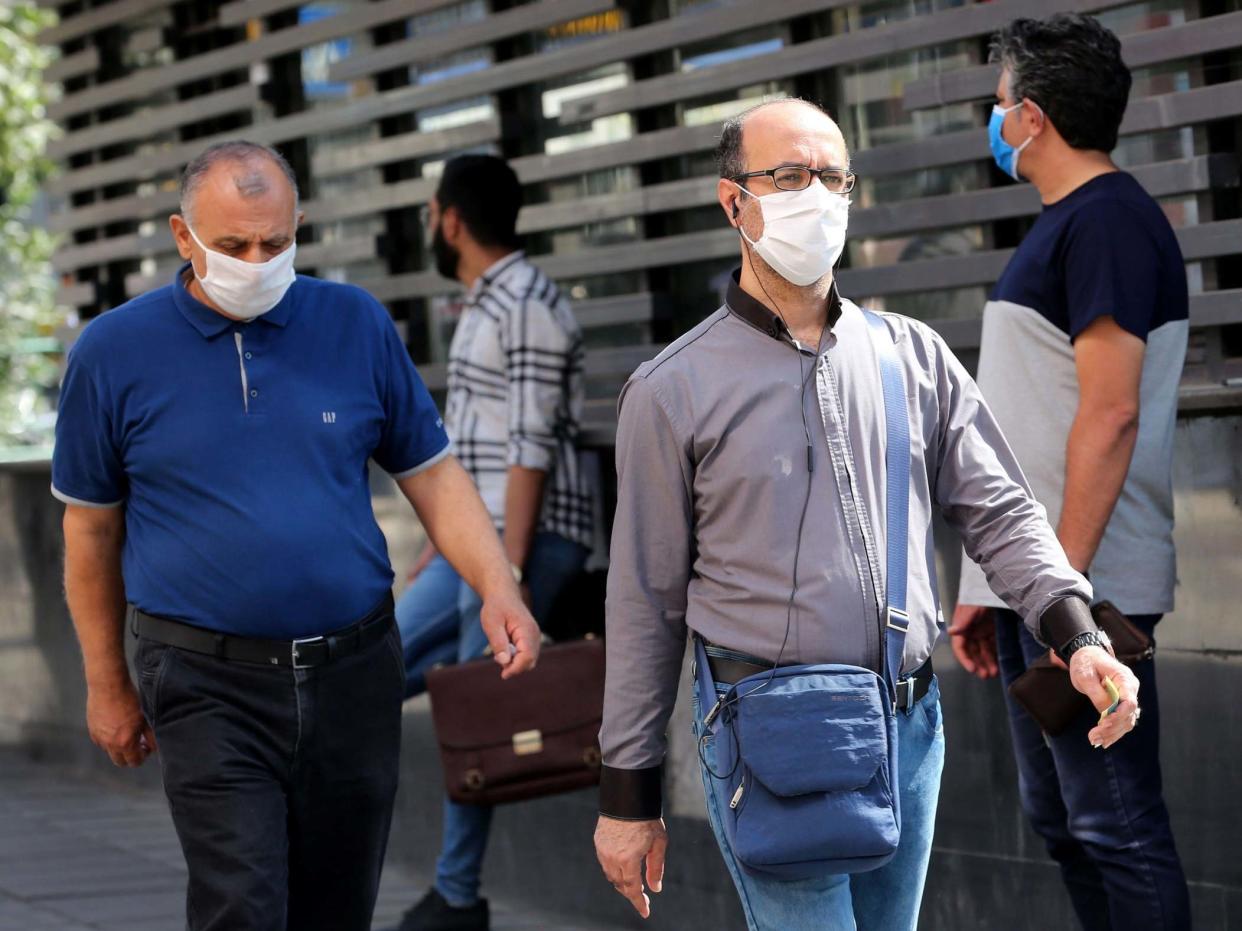 Iranians wearing face masks walk past in a street of Tehran, Iran, 04 August 2020: EPA