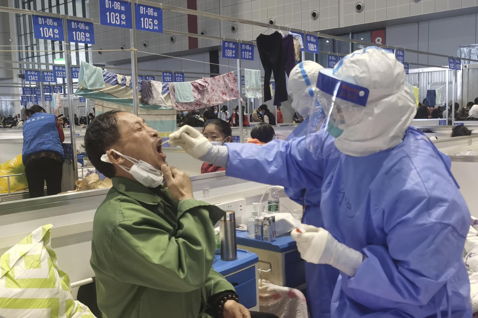 Residents get tested during their stay at a temporary hospital converted from the National Exhibition and Convention Center to quarantine COVID-positive people in Shanghai, China on April 18, 2022. Interviews with family members of people testing positive for COVID-19, a phone call with a government health official and an independent tally raise questions about how Shanghai calculates virus cases and deaths, almost certainly resulting in a marked undercount. (Chinatopix via AP)