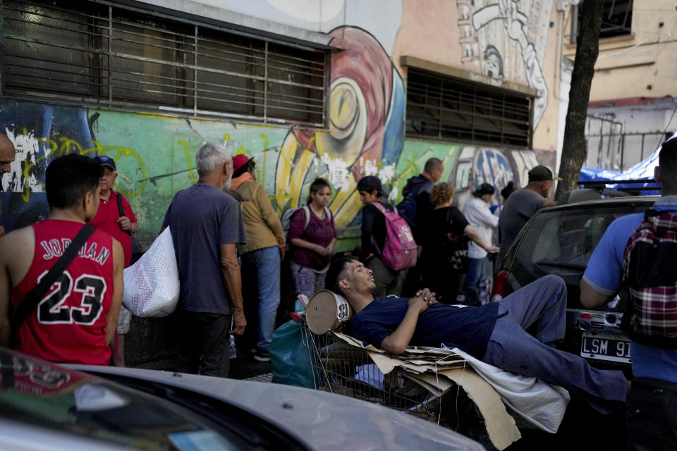 ARCHIVO - Personas hacen fila para recibir una comida caliente gratuita afuera de un comedor de beneficencia perteneciente al Movimiento de Trabajadores Excluidos (MTE) en Buenos Aires, Argentina, el viernes 8 de marzo de 2024. (AP Foto/Natacha Pisarenko, Archivo)