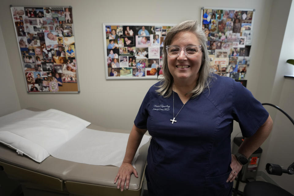Dr. Pam Evans, an obstetrician, poses in one of her exam rooms that is decorated with photographs of children she has delivered at the Henry County Medical Center in Paris, Tenn., on Tuesday, Aug. 29, 2023. With the closing of the maternity ward at the facility in early September, Evans fears that things like preterm deliveries, infant mortality and low-birthweight babies — a measure in which the county already ranks poorly — are bound to get worse. (AP Photo/Mark Humphrey)