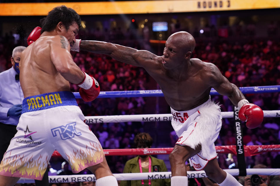 Yordenis Ugas, right, of Cuba, reaches in to hit Manny Pacquiao, of the Philippines, in a welterweight championship boxing match Saturday, Aug. 21, 2021, in Las Vegas. (AP Photo/John Locher)