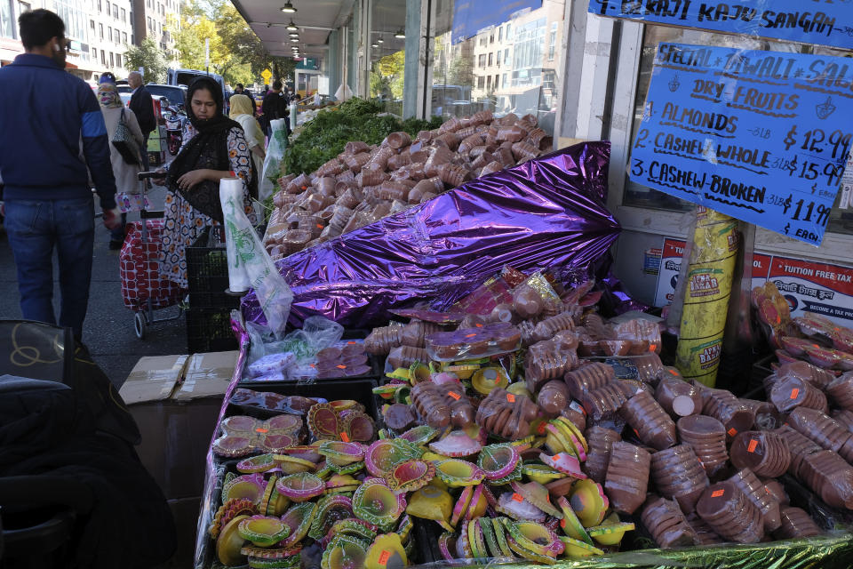 Clay pots and wicks for Diwali lamps are displayed alongside fresh cilantro at Apna Bazaar in the Jackson Heights section of the Queens borough of New York on on Oct. 22, 2022. (AP Photo/Mallika Sen)