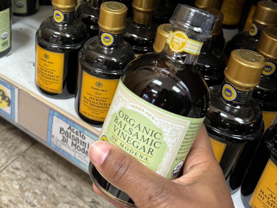 hand holding up a bottle of organic balsamic vinegar at trader joes