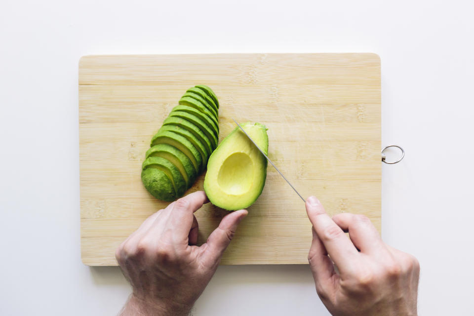 person with questionable knife skills cutting an avocado