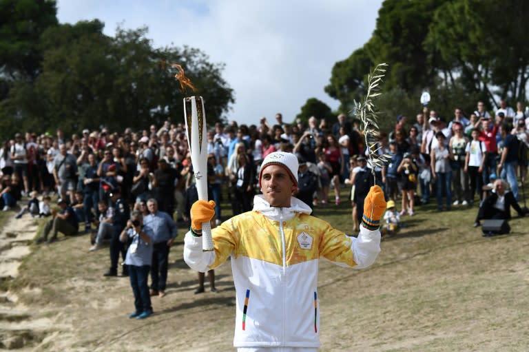 First Greek torchbearer for Pyeongchang 2018, cross-country skier Apostolos Angelis, holds the Olympic flame at the Temple of Hera, on October 23, 2017, during a dressed rehearsal of the lighting ceremony of the Olympic flame