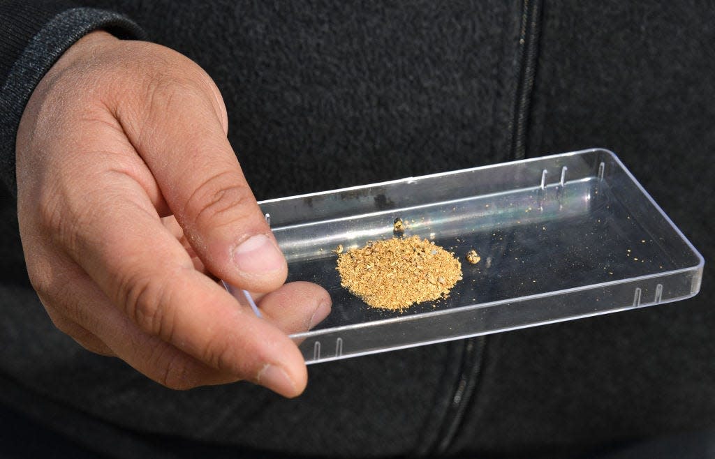 An Uzbekistan gold miner shows some of his product