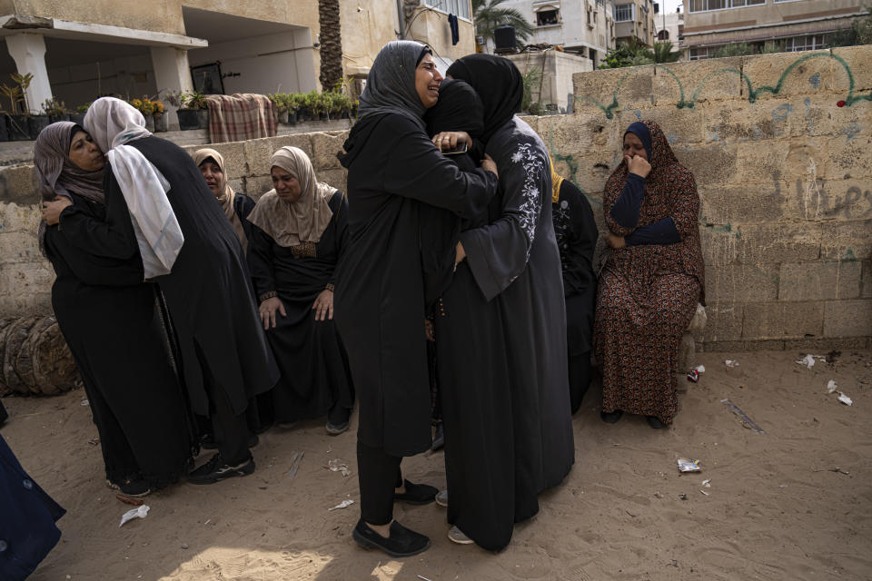 Relatives mourn people killed in an Israeli air strike in Gaza City on Monday, Oct. 9, 2023. Israel's military battled to drive Hamas fighters out of southern towns and seal its borders Monday as it pounded the Gaza Strip. (AP Photo/Fatima Shbair)