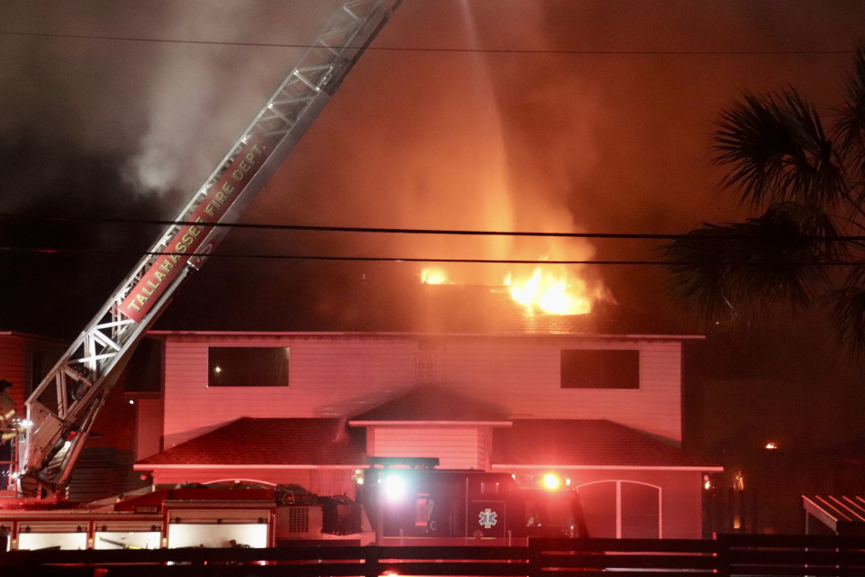 The blaze engulfed the second floor of a home in the complex and burned a large hole in its roof.