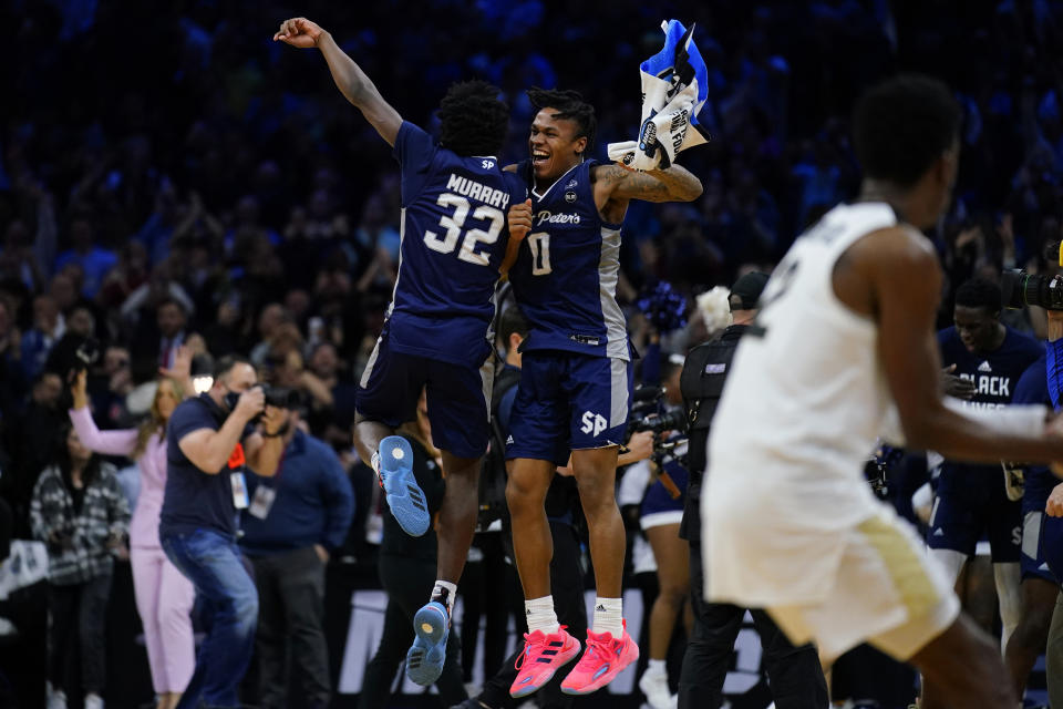 FILE - Saint Peter's Jaylen Murray, left, and Latrell Reid celebrate after their team won a college basketball game against Purdue in the Sweet 16 round of the NCAA tournament March 25, 2022, in Philadelphia. Saint Peter’s, the New Jersey men’s basketball team that made a long-shot run to the Elite Eight of the March Madness tournament this year, was among the most profitable teams for sports bettors in 2022. (AP Photo/Matt Rourke, File)