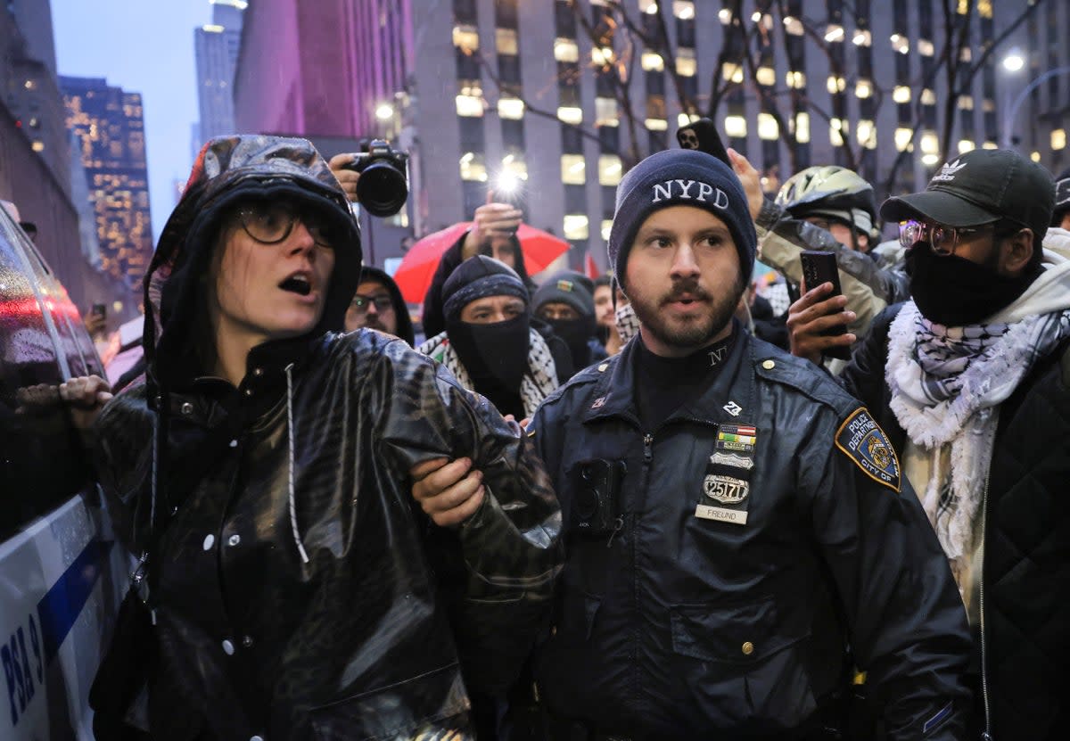 A protester is detained outside the venue (REUTERS)