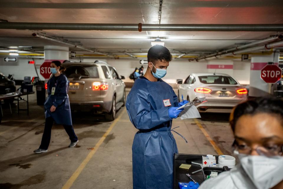 Amjed Jadallah goes over paperwork while working to administer shots of the Moderna COVID-19 vaccine in an underground parking garage at TCF Center in downtown Detroit on Wednesday, February 3, 2021 as part of a drive-up distribution for the city of Detroit.