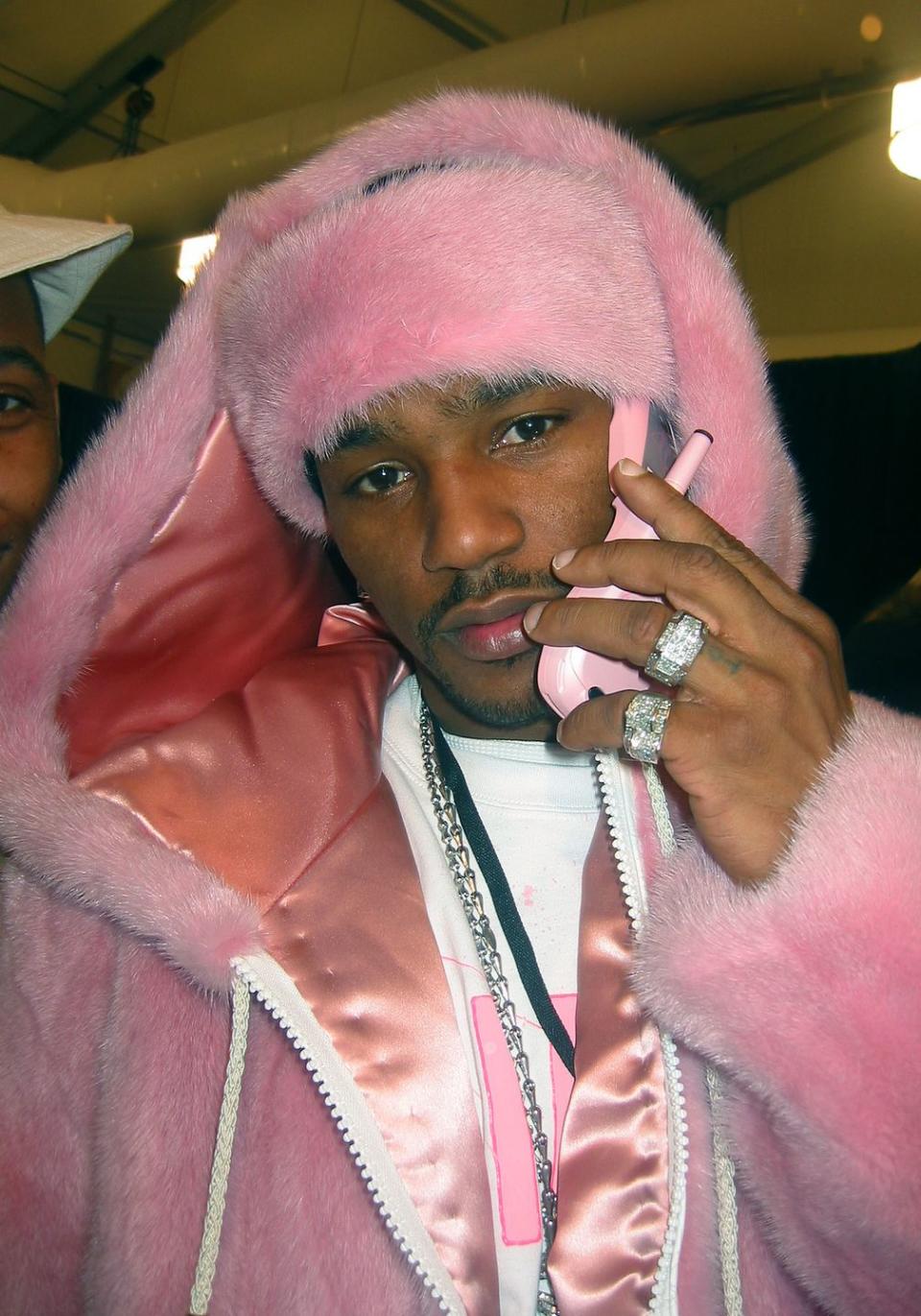 a famous photo of the rapper cam'ron wearing a pink fur coat and holding on a pink mobile phone up to his ear