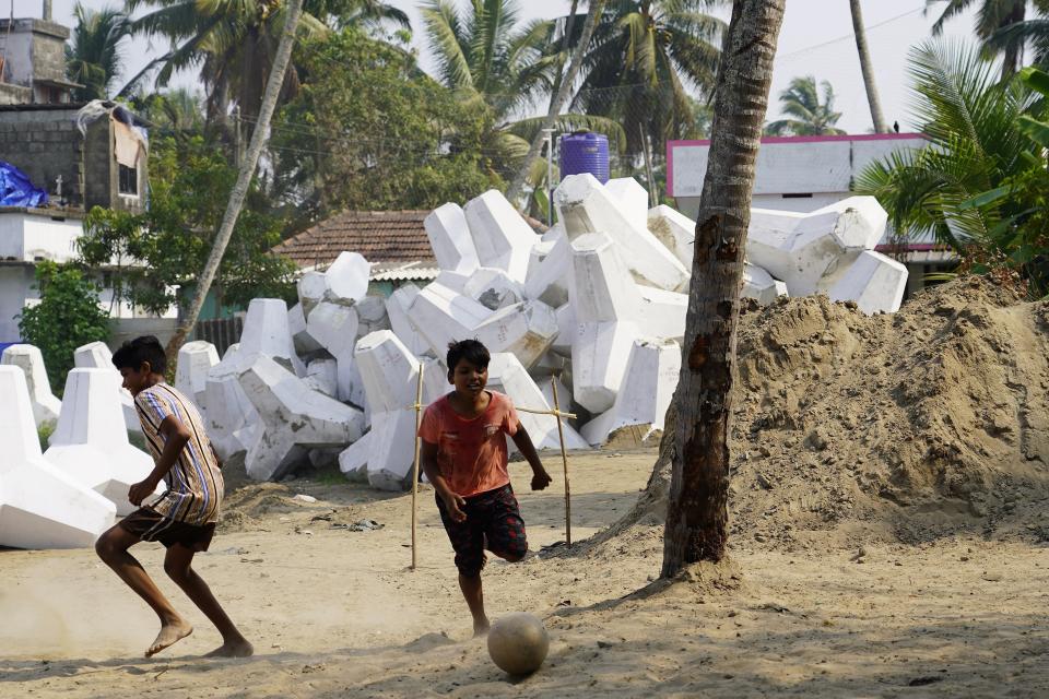 Children play soccer near a pile of tetrapods that will be part of a new sea wall in Kochi, Kerala state, India, March 4, 2023. Tens of millions of people in India live along coastlines and thus are exposed to major weather events. (AP Photo)