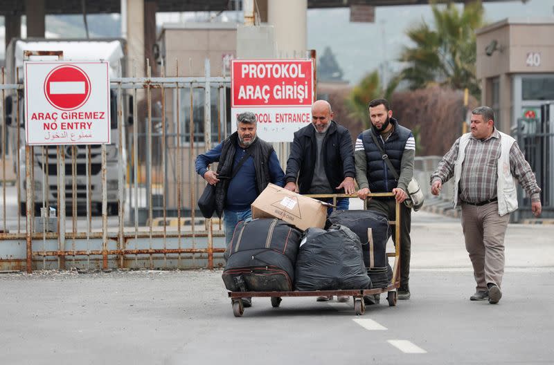 Syrians cross into Turkey through the Cilvegozu border gate, located opposite the Syrian commercial crossing point Bab al-Hawa, in Reyhanli, Hatay province