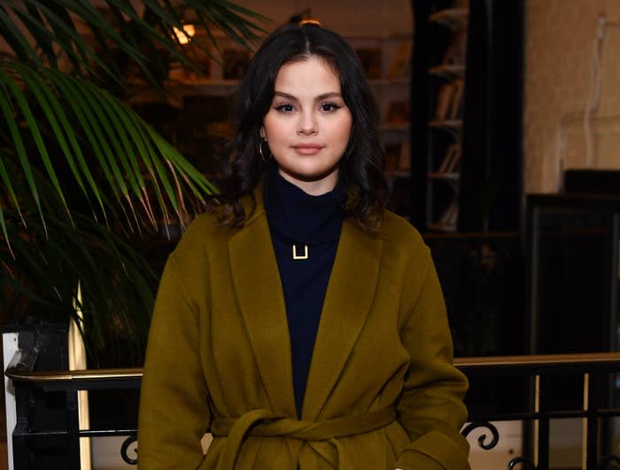 Close-up of Selena wearing a belted coat