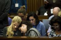 Aimee Pistorius, sister of Olympic and Paralympic track star Oscar, rests her head on an unidentified woman's shoulder during the fifth day of his trial for the murder of his girlfriend Reeva Steenkamp at the North Gauteng High Court in Pretoria, March 7, 2014. REUTERS/Theana Breugem/Pool (SOUTH AFRICA - Tags: SPORT ATHLETICS CRIME LAW)