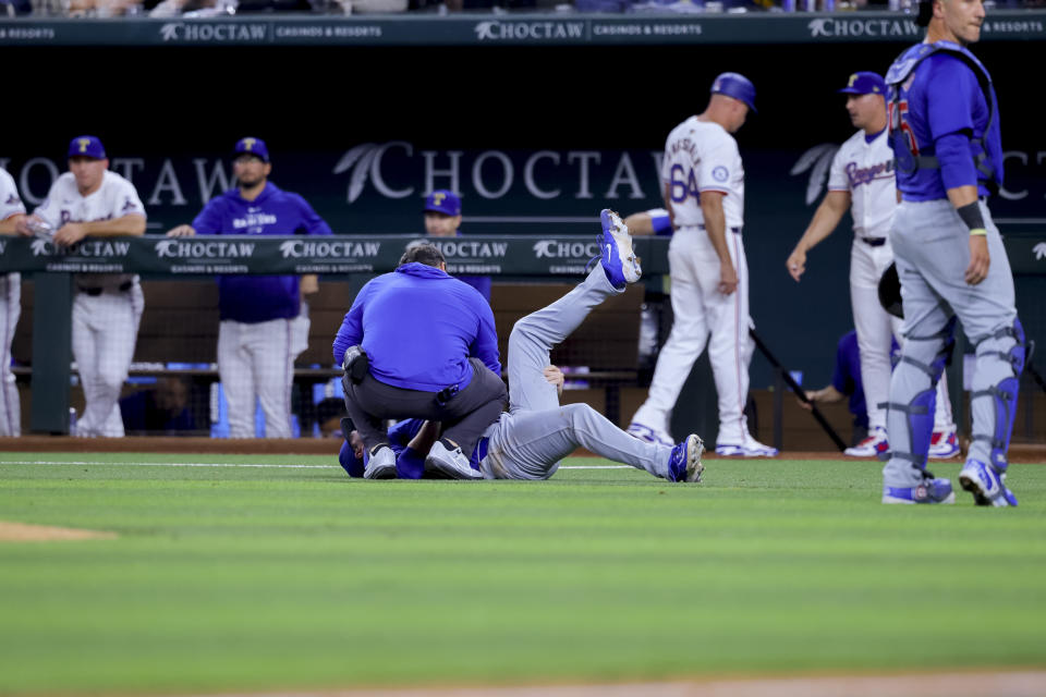 Chicago Cubs starting pitcher Justin Steele lies on the ground, holding his left leg during the fifth inning of the team's baseball game against the Texas Rangers, Thursday, March 28, 2024 in Arlington, Texas. (AP Photo/Gareth Patterson)