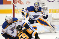 Pittsburgh Penguins' Jake Guentzel (59) gets off a shot in front of St. Louis Blues goaltender Jordan Binnington (50) with Colton Parayko (55) defending during the first period of an NHL hockey game in Pittsburgh, Wednesday, Jan. 5, 2022. (AP Photo/Gene J. Puskar)