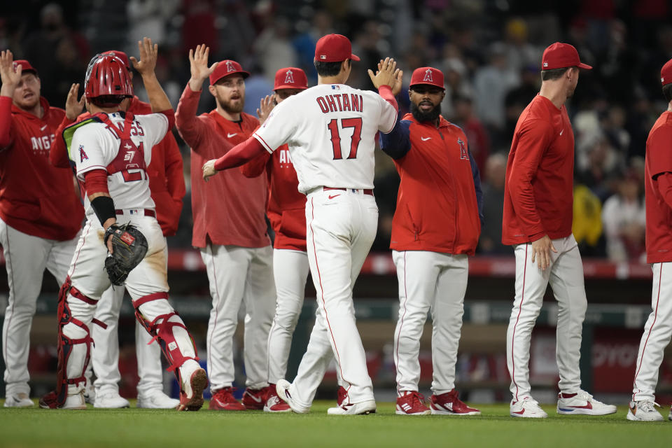 Los Angeles Angels designated hitter Shohei Ohtani (17) high-fives celebrates with teammates after a 6-4 win over the Houston Astros in a baseball game in Anaheim, Calif., Monday, May 8, 2023. (AP Photo/Ashley Landis)