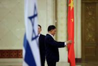 Staff members set up national flags ahead of a welcoming ceremony for Israeli Prime Minister Benjamin Netanyahu at the Great Hall of the People in Beijing, China March 20, 2017. REUTERS/Jason Lee