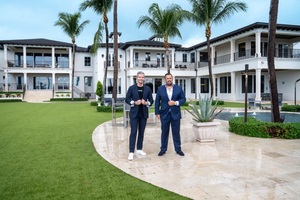 Former "Million Dollar Listing New York" star Ryan Serhant (left) and Christian Prakas post in front of a home at 526 North Ocean Boulevard in Delray Beach on Sept. 27, 2023. Prakas is managing broker of Serhant's Delray Beach real estate office.