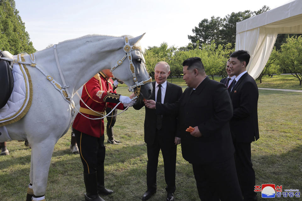 In this photo provided by the North Korean government, North Korean leader Kim Jong Un, front right, and Russia's President Vladimir Putin, center, chat at a garden of the Kumsusan State Guest House in Pyongyang, North Korea Wednesday, June 19, 2024. The content of this image is as provided and cannot be independently verified. Korean language watermark on image as provided by source reads: "KCNA" which is the abbreviation for Korean Central News Agency.(Korean Central News Agency/Korea News Service via AP)