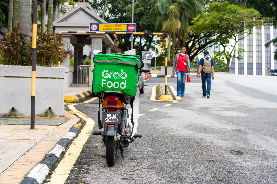 Food delivery bike with a big bag for transporting food. Fast food delivery without traffic jams. Kuala Lumpur / Malaysia - 04.06.2020