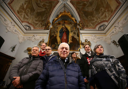 The church's priest Giuseppe Gambardella (C), 76, known to everyone as Don Peppino, poses with his collaborators in Pomigliano D'Arco, near Naples, Italy, February 21, 2018. Picture taken February 21, 2018. REUTERS/Alessandro Bianchi