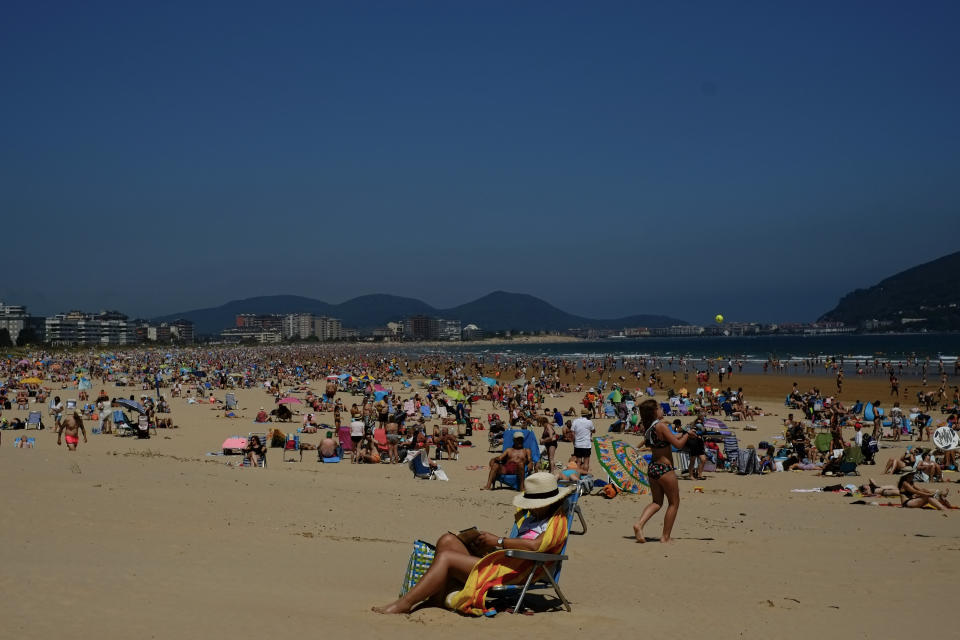 FILE - In this file photo dated Saturday, July 17, 2021, people on the beach during a summer's day, in Laredo, northern Spain. Europe’s famed summer holiday season is in full swing, but efforts to inoculate people against coronavirus are not taking a break. From France’s Mediterranean coast to Italy’s Adriatic beaches, health authorities are trying to make a COVID-19 shot as much a part of this summer as sunscreen and shades. (AP Photo/Alvaro Barrientos, FILE)