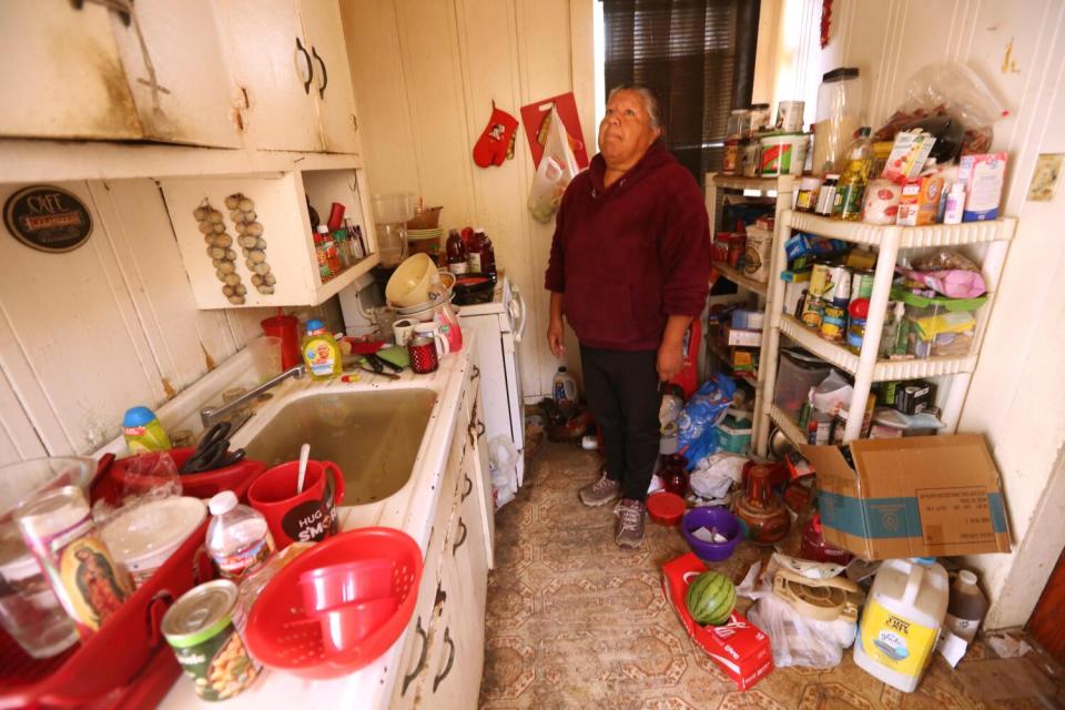 A woman in a flood-damaged kitchen