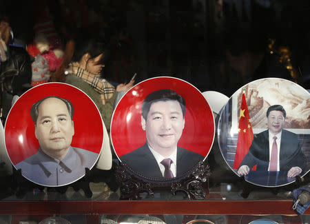 Souvenir plates bearing the images of China's President Xi Jinping and China's late Chairman Mao Zedong (L) are displayed at a shop nearby the Great Hall of the People where the National People's Congress will be held, in Beijing March 4, 2015. REUTERS/Kim Kyung-Hoon