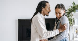 Black man speaking aggressively to Black woman as he grips her arm.