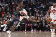 Brooklyn Nets guard Lonnie Walker IV, left, bumps Toronto Raptors guard Javon Freeman-Liberty (0) off the ball as teammate Ochai Agbaji (30) looks on during the first half of an NBA basketball game in Toronto, Monday, March 25, 2024. (Nathan Denette/The Canadian Press via AP)