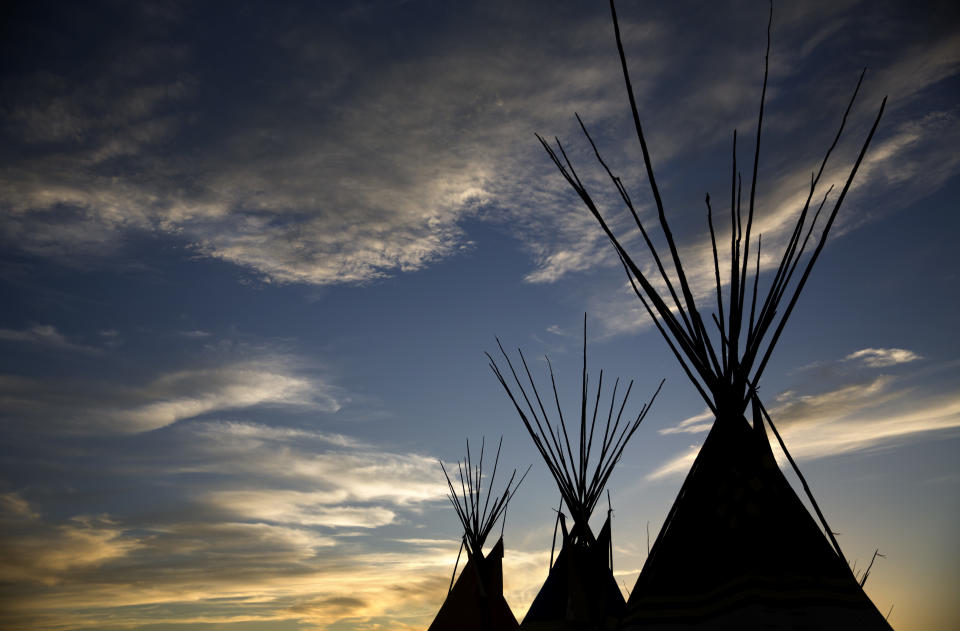 FILE - The sun sets during the North American Indian Days celebration on the Blackfeet Indian Reservation in Browning, Mont., on July 13, 2018. Many Native Americans thought a bitter debate over the U.S. capital’s football mascot was over when the team became the Washington Commanders. The original logo was designed by a member of the Blackfeet Nation. Now a white Republican U.S. senator from Montana is reviving the debate by blocking a bill funding the revitalization of the team's stadium unless the NFL and the Commanders bring back the former logo in some form. (AP Photo/David Goldman, File)