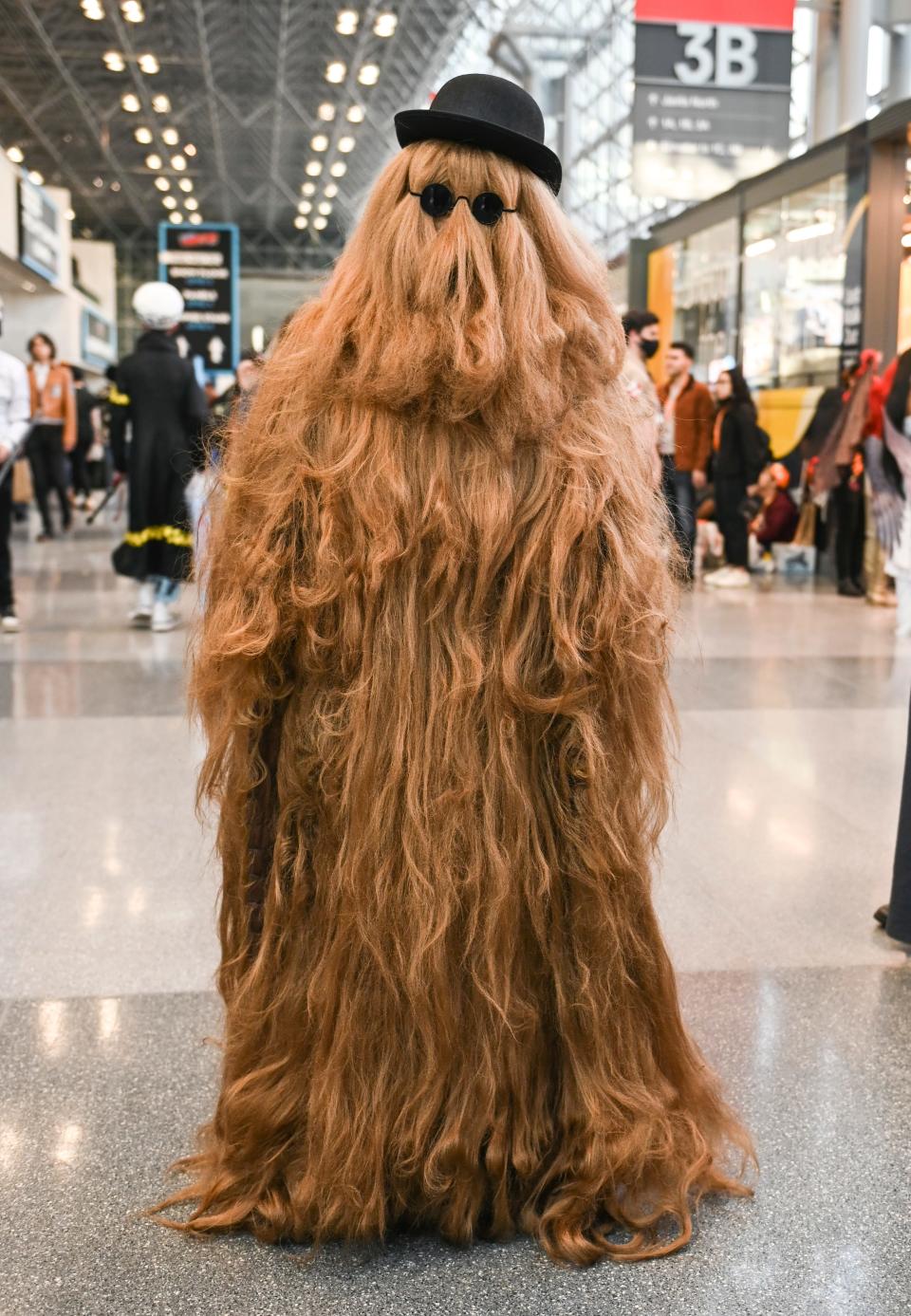 A cosplayer dressed as Cousin It at New York Comic Con 2022.