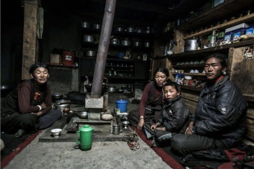 This handout photo, released by www.thegreathimalayatrail.org on September 18, shows Tashi Sangmo Lama, 31, (2nd L) with 25-year old Pasang Lama (R), one of the two husbands in her polyandrous marriage, and their eight-year-old son Pema (2nd R) as they take tea with a relative at their home in the remote Himalayan region of Upper Dolpa, some 500 km from the Nepalese capital Kathmandu