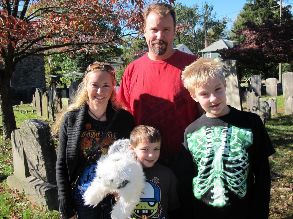 In this Oct. 18, 2013 photo, Jill Werner, Colin Werner, Doug Werner and Christian Werner of Greenwood, Ind., pose for a photo at historic Sleepy Hollow Cemetery in Sleepy Hollow, N.Y. The village of Sleepy Hollow is even busier than usual this Halloween, thanks to a new "Sleepy Hollow" TV series inspired by the tale of the Headless Horseman. (AP Photo/Jim Fitzgerald)