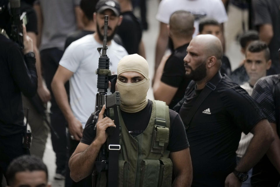 Palestinian militants attend the funeral of Ahmad Awawda, 19, who was killed in clashes with Israeli troops near the city of Nablus the previous day, in the the West Bank city of Jenin, Sunday, Oct. 8, 2023. (AP Photo/Majdi Mohammed)