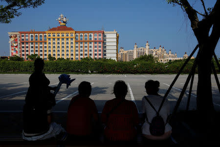Visitors rest in front of Chimelong Hengqin Bay Hotel (R) and Chimelong Circus Hotel at Hengqin Island adjacent to Macau, China September 13, 2017. REUTERS/Bobby Yip