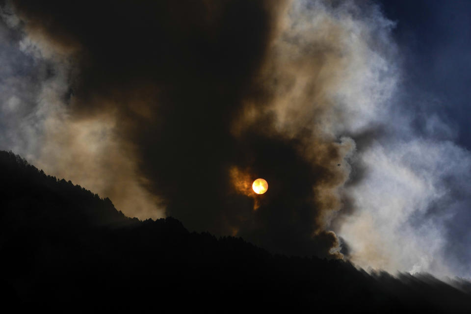 The sun rises during a forest fire on El Cable Hill in Bogota, Colombia, Thursday, Jan. 25, 2024. (AP Photo/Fernando Vergara)