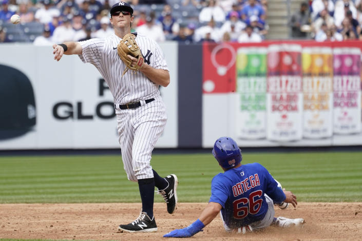New York Yankees second baseman DJ LeMahieu, left, throws to first to complete a double play after forcing out Chicago Cubs' Rafael Ortega (66) in the second inning of a baseball game, Sunday, June 12, 2022, in New York. (AP Photo/Mary Altaffer)