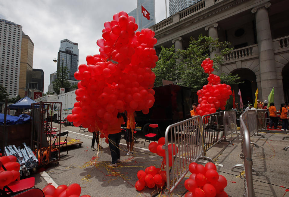 FILE - In this Friday, July 1, 2011, file photo, participants hold red balloons during a ceremony at a downtown Hong Kong street to celebrate the 14th anniversary of Hong Kong's handover to China. Just two years ago, hundreds of thousands of Hong Kongers took to the streets protesting against proposed extradition legislation that might have resulted in some residents facing trial in mainland Chinese courts. Now, protesting or publishing anything that might be construed as a violation of the security law can land them in jail in Hong Kong. (AP Photo/Vincent Yu, File)