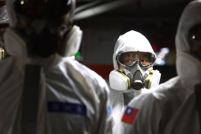 Soldiers prepare to spray disinfectant at the Taoyuan General Hospital in Taoyuan