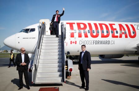Liberal leader and Canadian Prime Minister Justin Trudeau waves as he leaves his plane at the airport during an election campaign visit to Vancouver,