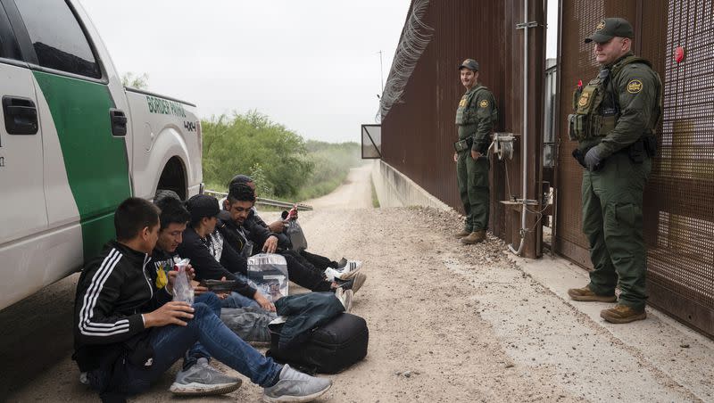 Colombian migrants that were trying to evade U.S. Border Patrol wait to be processed near the port of entry in Hidalgo, Texas, Thursday, May 4, 2023. A recent surge of migrants in the Brownsville area of the U.S.-Mexico border is highlighting immigration challenges as the U.S. prepares for the end of a policy linked to the coronavirus pandemic that allowed it to quickly expel many migrants.