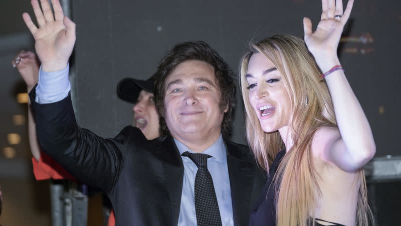 Presidential candidate of the Liberty Advances coalition Javier Milei, right, and his girlfriend Fatima Florez wave to supporters outside his campaign headquarters after winning the runoff election in Buenos Aires, Argentina, on Nov. 19, 2023.