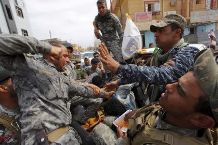 A member from the Iraqi security forces beats an Islamic State insurgent, who was captured in Tikrit, April 1, 2015. REUTERS/Alaa Al-Marjani