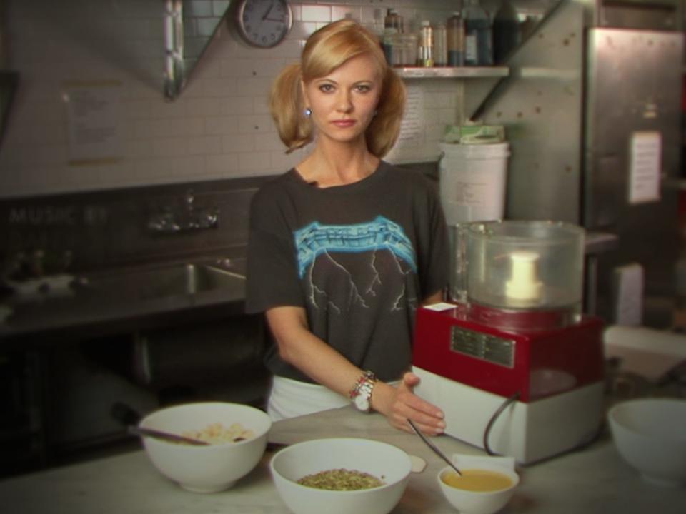 Sarma Melngailis standing in a kitchen using appliances on Bad Vegan: Fame. Fraud. Fugitives.