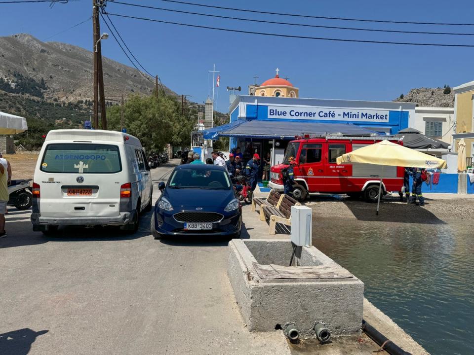 An ambulance and a fire brigade on a Symi beachfront on Sunday (AP)